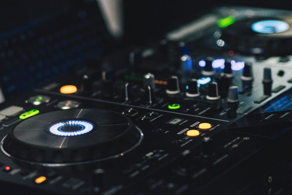 A detailed shot of professional DJ equipment featuring knobs and LED lights, perfect for music events.